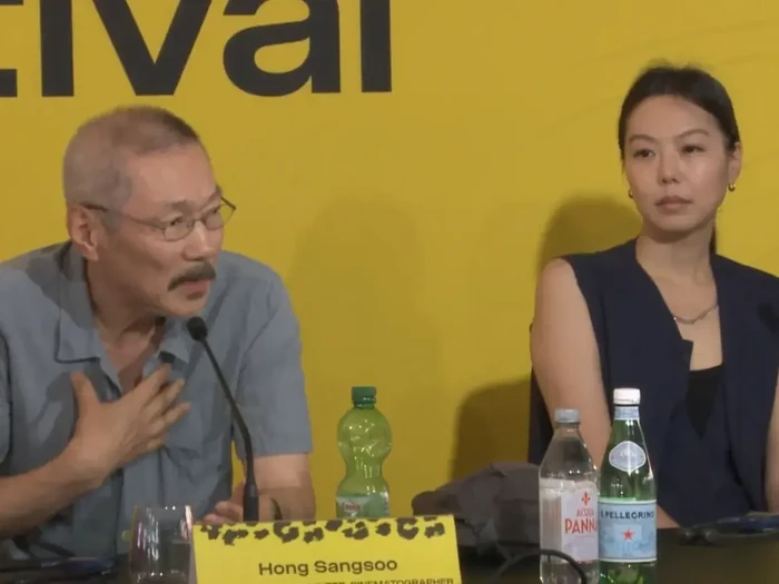 Penampilan Kim Min Hee,  aktris kontroversial yang menjadi orang ketiga dalam pernikahan sutradara Hong Sang Soo. Keduanya muncul bersama di Festival Film Locarno 2026.