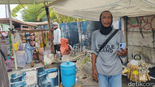 Seorang pria yang belum diketahui asal usulnya viral di medsos karena gerak-gerik janggal seolah sedang mengintai sambil menenteng benda mirip pistol. (M Syahid A/detikcom)