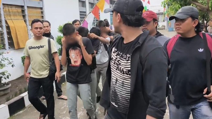 Petugas kepolisian saat menjemput para pelaku dari sekolah.