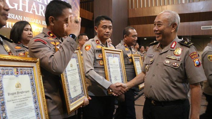 Wakapolres Bojonegoro Kompol Ferry Dharmawan jabat tangan dengan pimpinan setelah terima penghargaan.