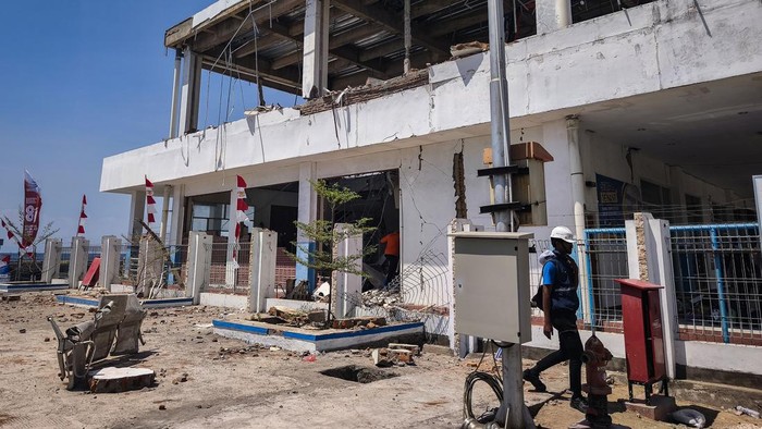 Petugas melintas di dekat bangunan Pelabuhan Laurentius Say Maumere yang rusak akibat gempa di Kabupaten Sikka, Nusa Tenggara Timur (NTT), Sabtu (15/8/2026).