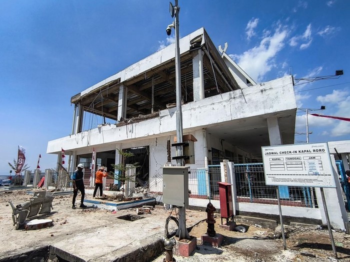 Petugas melintas di dekat bangunan Pelabuhan Laurentius Say Maumere yang rusak akibat gempa di Kabupaten Sikka, Nusa Tenggara Timur (NTT), Sabtu (15/8/2026). Badan Penanggulangan Bencana Daerah (BPBD) Kabupaten Sikka melaporkan terdapat tiga korban jiwa dari ambruknya gedung ruang tunggu pelabuhan yang diguncang gempa bumi magnitudo (M) 7,7 tersebut. ANTARA FOTO/Gregorio J Gilbert/sth/nz