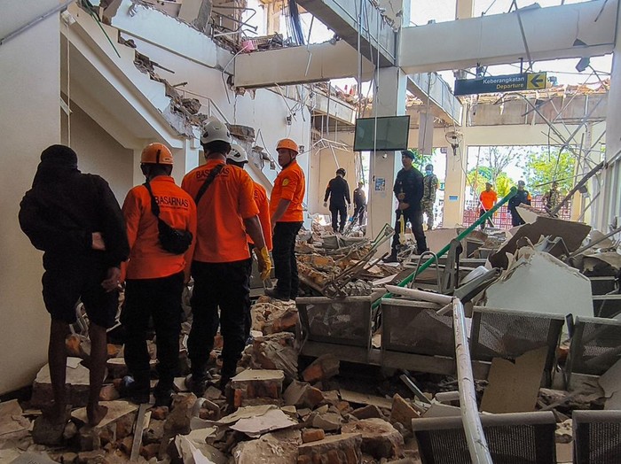 Petugas melintas di dekat bangunan Pelabuhan Laurentius Say Maumere yang rusak akibat gempa di Kabupaten Sikka, Nusa Tenggara Timur (NTT), Sabtu (15/8/2026). Badan Penanggulangan Bencana Daerah (BPBD) Kabupaten Sikka melaporkan terdapat tiga korban jiwa dari ambruknya gedung ruang tunggu pelabuhan yang diguncang gempa bumi magnitudo (M) 7,7 tersebut. ANTARA FOTO/Gregorio J Gilbert/sth/nz