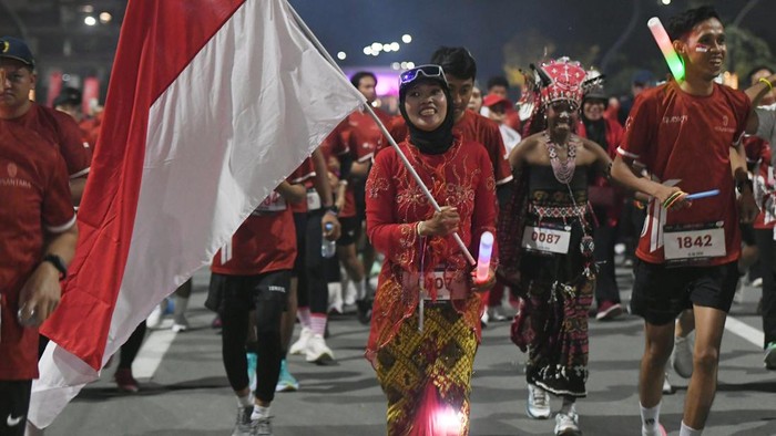 Peserta membawa bendera Merah Putih saat mengikuti  Merdeka Night Run di Ibu Kota Nusantara (IKN), Penajam Paser Utara, Kalimantan Timur, Sabtu (15/8/2026). Otorita IKN menyelenggarakan Merdeka Night Run yang diikuti sekitar 3000 peserta sebagai rangkaian perayaan HUT ke-81 Kemerdekaan RI sekaligus sebagai upaya memperkuat interaksi sosial di Nusantara. ANTARA FOTO/Angga Palguna/wpa.