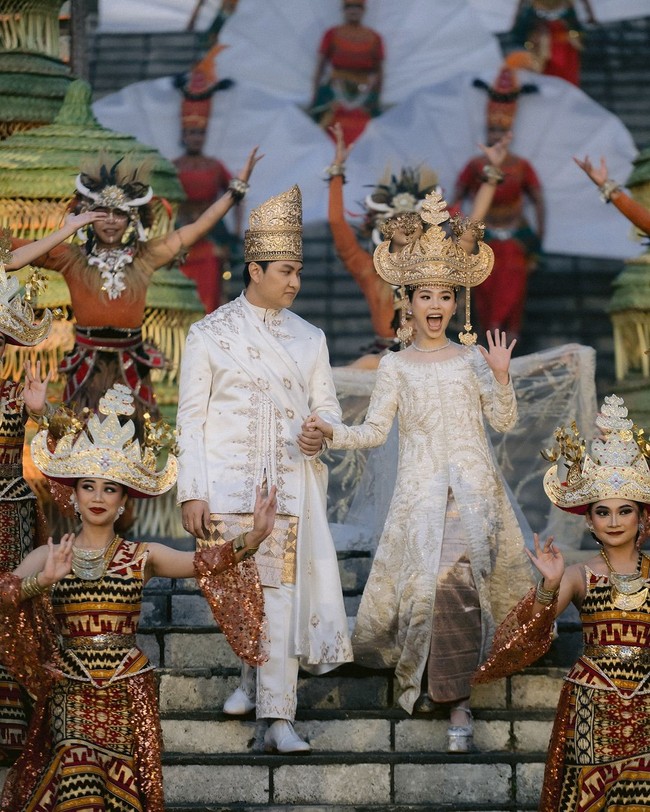 Busana pengantin pria merupakan kreasi dari Tangan Prive, sementara gaun panjang dengan hiasan bordir emas dari koleksi Biyan The Gallery. Foto: Instagram/@dikhadheansa @biyan_the_gallery @venema.bali