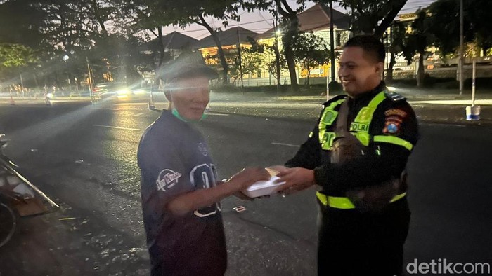 Personel Satlantas Polresta Sidoarjo berbagi nasi bungkus usai Subuhan.
