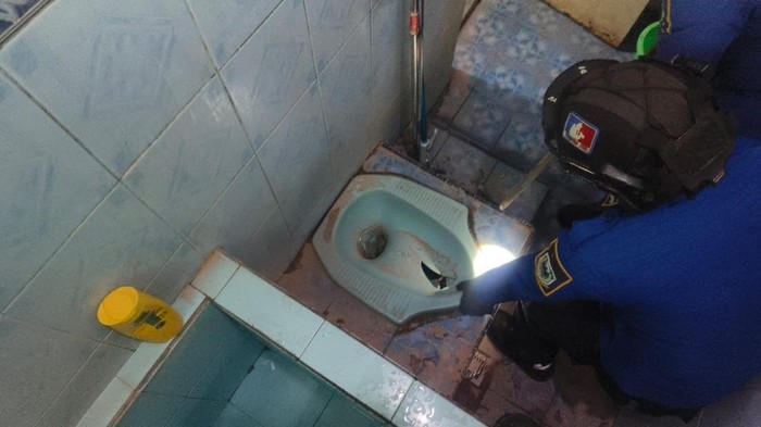 Proses evakuasi ular sanca yang masuk toilet rumah warga Kuningan