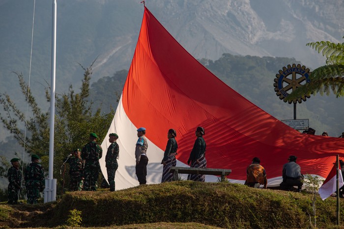 Petugas membawa Bendera Merah Putih raksasa yang akan dikibarkan saat upacara di lereng Gunung Merapi, Bukit Klangon, Cangkringan, Sleman, D.I. Yogyakarta, Minggu (16/8/2026). Pengibaran Bendera Merah Putih berukuran 9x6 meter tersebut diikuti ribuan peserta dari berbagai elemen masyarakat dalam memperingati HUT ke-81 RI.   ANTARA FOTO/Andreas Fitri Atmoko