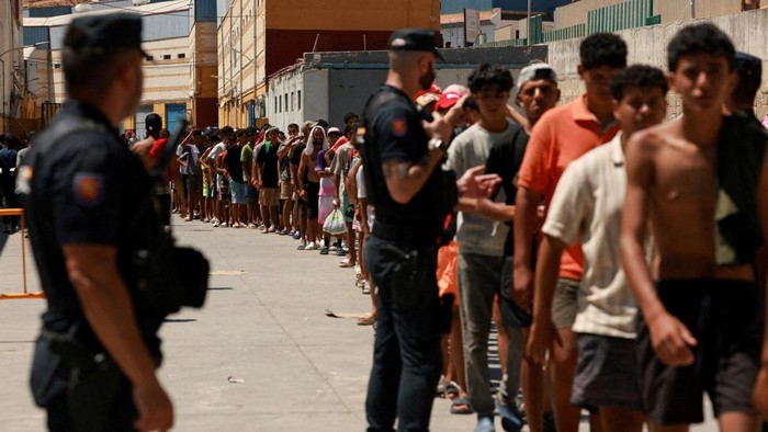 Foto: Para migran antre untuk mendapat makanan dari LSM di Ceuta (REUTERS/Violeta Santos Moura)