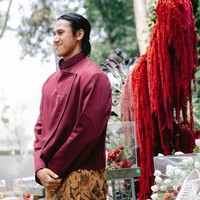 Sementara Sean mengenakan beskap modern rancangan desainer Didiet Maulana. Bagian tepi busana dihiasi detail bordir atau jahitan dekoratif yang senada, sehingga memberikan sentuhan mewah tanpa terlihat berlebihan. Sebagai bawahan, ia memakai kain batik berwarna cokelat keemasan dengan motif yang cukup ramai, memadukan unsur flora dan ornamen khas batik. Foto: Instagram/@hanamalasan