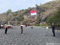 Bendera Raksasa Berkibar di Tebing Pantai Dampar Lumajang