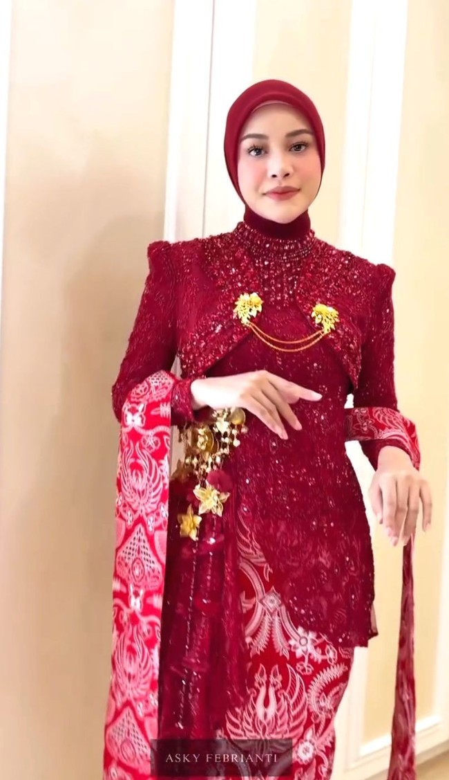 Aurel Hermansyah menghadiri upacara HUT ke-81 RI di Istana Merdeka, Senin (17/8/2026) dengan mengenakan kebaya rancangan Asky Febrianty bernuansa merah. Kebaya berpayet tersebut dipadukan dengan kain batik merah bermotif klasik, lengkap dengan detail bros emas dan aksesori selendang merah-putih. Foto: Dok. Instagram hummingbirdroad, hagaipakan, cita rahayu, marcel siahaans, angel pieters
