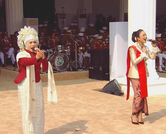 Krisdayanti dan Melly Goeslaw duet menyanyikan lagu Indonesia Jaya saat Upacara HUT ke-81 RI di Istana Negara. KD tampil memesona dengan busana rancangan Sebastian Gunawan. Sementara itu, Melly Goeslaw tampil tak kalah mencuri perhatian dalam busana karya Wilsen Willim, menonjolkan sentuhan merah dan putih yang dipadukan dengan kain bernuansa tradisional.  Foto: Dok. Instagram hummingbirdroad, hagaipakan, cita rahayu, marcel siahaans, angel pieters