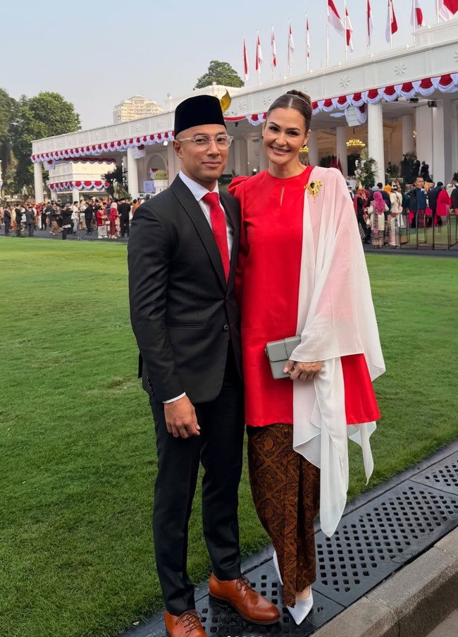 Penyanyi Marcel Siahaan mengenakan setelan jas hitam lengkap dengan kemeja putih, dasi merah, peci hitam, dan sepatu kulit cokelat saat menghadiri upacara HUT ke-81 RI di Istana Negara. Sementara sang istri, Rima, tampil anggun memakai baju kurung merah yang dipadukan kain batik cokelat, selendang putih, serta aksesori emas. Foto: Dok. Instagram hummingbirdroad, hagaipakan, cita rahayu, marcel siahaans, angel pieters