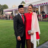 Penyanyi Marcel Siahaan mengenakan setelan jas hitam lengkap dengan kemeja putih, dasi merah, peci hitam, dan sepatu kulit cokelat saat menghadiri upacara HUT ke-81 RI di Istana Negara. Sementara sang istri, Rima, tampil anggun memakai baju kurung merah yang dipadukan kain batik cokelat, selendang putih, serta aksesori emas. Foto: Dok. Instagram hummingbirdroad, hagaipakan, cita rahayu, marcel siahaans, angel pieters