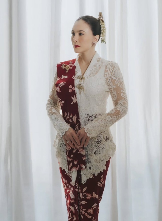 Wulan Guritno tampil memesona saat menghadiri Upacara HUT ke-81 RI di Istana Negara dalam balutan kebaya brokat warna putih rancangan Didi Budiardjo. Ia memadukannya dengan kain dari Batik Keris bermotif floral bernuansa merah marun, serta sanggul klasik dengan hiasan bunga yang menyempurnakan penampilannya. Foto: Dok. Instagram hummingbirdroad, hagaipakan, cita rahayu, marcel siahaans, angel pieters