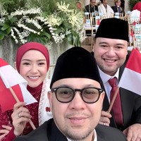 Gaya hijab merah polos dengan model clean look membingkai riasan wajah Cita yang flawless. Kebaya brokat berkerah tinggi yang dikenakannya makin serasi saat disandingkan dengan selendang putih dan bendera kecil yang dipegangnya. Foto: Dok. Instagram @cita_rahayu.