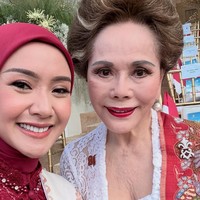 Swafoto ini memperlihatkan keharmonisan busana Cita Rahayu yang bernuansa merah-putih saat bersanding dengan Dewi Soekarno. Hijab merah marun tanpa motif dipadukan dengan kebaya brukat, memberikan kesan elegan tanpa berlebihan di samping busana kebaya putih klasik. Foto: Dok. Instagram @cita_rahayu.