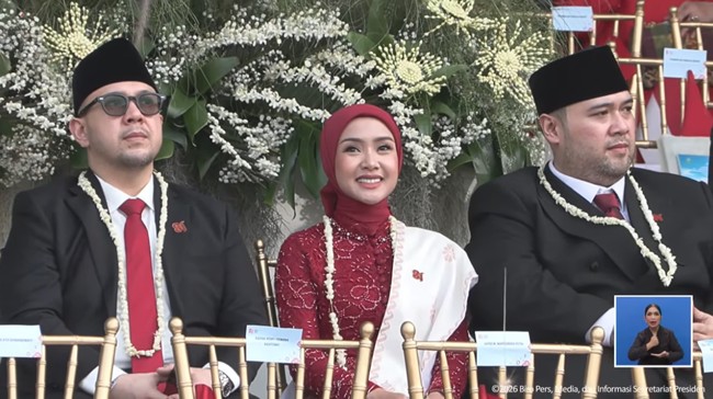 Saat duduk di podium acara, Cita Rahayu tampil memadukan kebaya brokat merah marun berdetail manik-manik dengan gaya hijab segi empat berwarna senada yang diikat rapi ke belakang. Sentuhan selendang putih bernuansa etnik yang disampirkan di bahu memberikan kontras yang pas sekaligus mempertegas nuansa kebangsaan. Foto: Dok. Instagram @cita_rahayu.