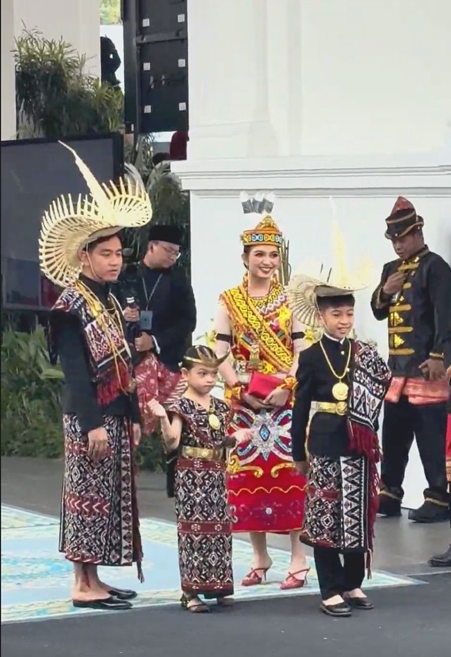 Sedangkan istri Gibran, Selvi Ananda memakai pakaian adat Dayak.Selvi juga melengkapi penampilannya dengan topi yang dihiasi bulu burung Enggang. Bulu tersebut mengandung simbol kesucian burung Enggang atau keelokan burung Ruai yang merefleksikan kecantikan serta kedaulatan perempuan  Foto: Dok. Instagram, 20detik, YouTube Setpres. Setwapres
