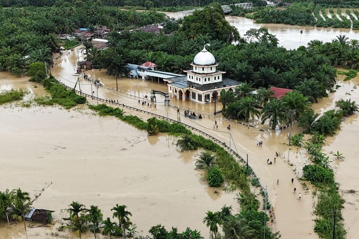Foto udara pengendara melintasi jalan nasional Medan-Banda Aceh yang terendam banjir di Desa Peuribu, Arongan Lambalek, Aceh Barat, Aceh, Kamis (27/11/2025). Bencana banjir yang melanda 16 kabupaten/kota di Aceh selain berdampak pada ratusan ribu warga juga merusak sejumlah badan jalan dan jembatan sehingga memutuskan akses transpotasi darat. ANTARA FOTO/Syifa Yulinnas/foc.