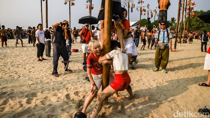 Ratusan peserta mengikuti panjat pinang kolosal di kawasan Ancol, Jakarta Utara, Senin (17/8/2026), dalam rangka memperingati Hari Ulang Tahun (HUT) ke-81 Republik Indonesia. Sebanyak 50 pohon pinang disiapkan dalam kegiatan yang melibatkan sekitar 300 peserta dari berbagai kalangan. Puluhan pohon pinang tersebut berdiri berjajar dan menjadi pusat perhatian pengunjung.