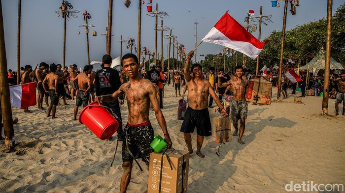 Ratusan peserta mengikuti panjat pinang kolosal di kawasan Ancol, Jakarta Utara, Senin (17/8/2026), dalam rangka memperingati Hari Ulang Tahun (HUT) ke-81 Republik Indonesia. Sebanyak 50 pohon pinang disiapkan dalam kegiatan yang melibatkan sekitar 300 peserta dari berbagai kalangan. Puluhan pohon pinang tersebut berdiri berjajar dan menjadi pusat perhatian pengunjung.