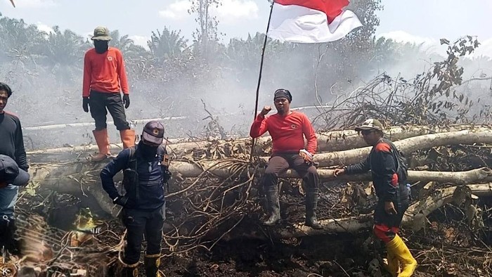 Petugas pemadam rayakan Hari Kemerdekaan di lokasi karhutla.