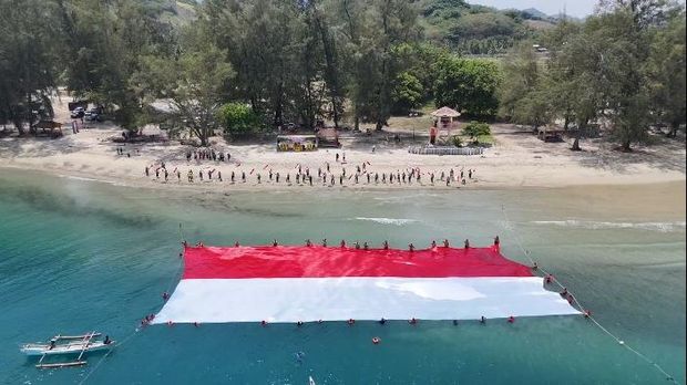 Polres Boalemo membentangkan bendera merah putih berukuran 40x20 meter di atas laut dalam rangka HUT RI ke-81. Dokumen Istimewa