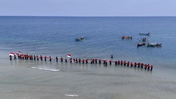 Polres Boalemo membentangkan bendera merah putih berukuran 40x20 meter di atas laut dalam rangka HUT RI ke-81. Dokumen Istimewa