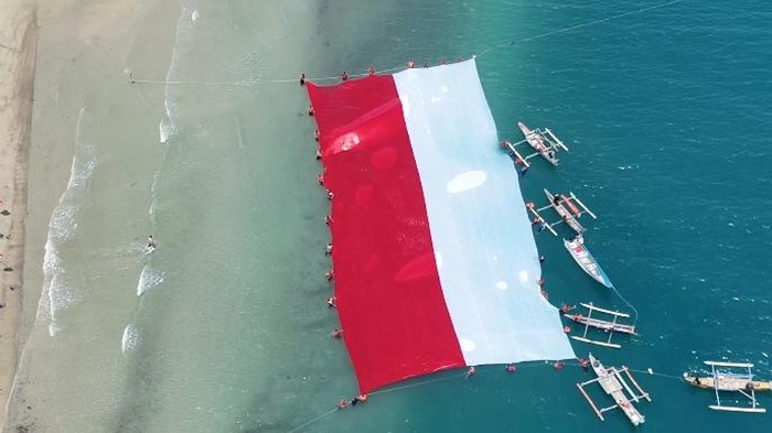 Polres Boalemo membentangkan bendera merah putih berukuran 40x20 meter di atas laut dalam rangka HUT RI ke-81. Dokumen Istimewa