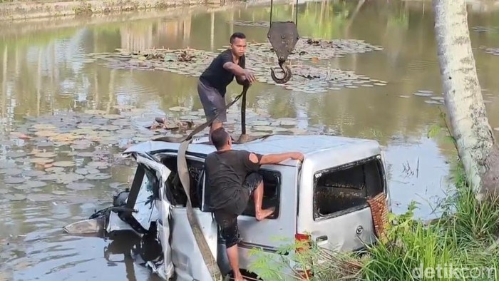 Proses evakuasi minibus yang masuk kolam ikan usai bertabrakan dengan truk.