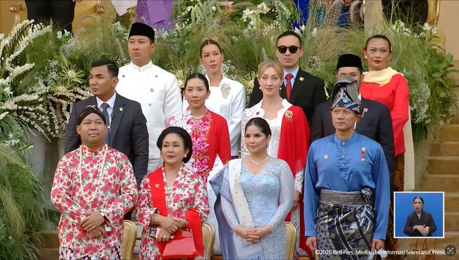 Titiek Soeharto duduk bersebelahan dengan putranya, Didit. Keduanya kompak kenakan busana adat Jawa dengan motif bunga-bunga berwarna merah. Titiek melengkapi penampilannya dengan selendang merah yang disampirkan di salah satu bahunya serta tas senada. Foto: YouTube/Sekretariat Presiden