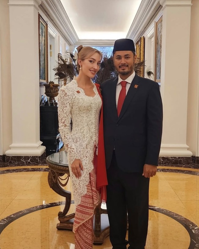 Varsha tampil serasi dengan suaminya yang mengenakan setelan jas hitam dipadukan dengan kemeja putih dan dasi merah. Ia juga tampak mengenakan kopiah hitam di kepalanya. Foto: Instagram/@varshaadikumoro