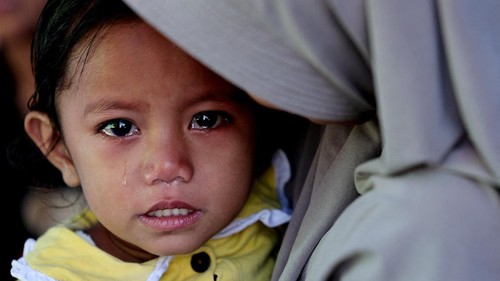 A girl stands next to a makeshift tent serving as temporary shelter for people affected by the earthquake in Reok, East Nusa Tenggara province, Indonesia, August 18, 2026. REUTERS/Willy Kurniawan