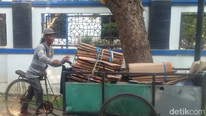 Salim sedang mendorong gerobaknya.