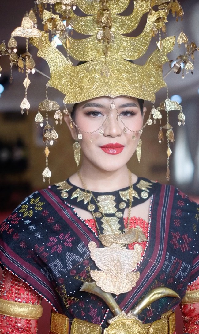 Sementara Kahiyang Ayu mendampingi suaminya, Gubernur Sumatera Utara, Bobby Nasution, menghadiri upacara HUT ke-81 RI di Lapangan Astaka, Pancing. Kahiyang tampil memukau dalam balutan pakaian adat Mandailing Sumatera Utara. Foto: Instagram/@bennusorumba