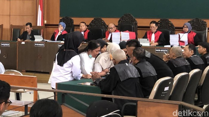 Para terdakwa berdiskusi dengan kuasa hukum dalam persidangan