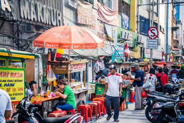 Vibrant street market in Jakarta, featuring locals and visitors engaging with food stalls and vendors. Captured on August 6th, 2023, this lively scene reflects urban culture and diversity.