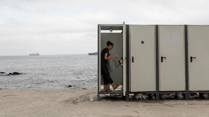 A migrant sits outside a makeshift shelter on a beach in Ceuta, Spain, August 18, 2026. Spain expanded migrant facilities in its North African enclave of Ceuta as shelters exceeded capacity following mass crossings of migrants from Morocco. REUTERS/Violeta Santos Moura