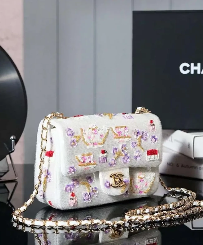Tas berwarna dasar silver itu dipenuhi detail sequin atau payet. Hiasannya hadir dalam perpaduan warna silver, pink, ungu, dan merah. Sementara itu, aksen rantai dan sejumlah detail logam menggunakan warna gold-tone. Desain flap dan bentuknya tetap mempertahankan karakter khas Mini Flap Bag Chanel. Tas tersebut juga dilengkapi rantai panjang sehingga dapat digunakan sebagai tas selempang atau disampirkan di bahu. Foto: Pinterest