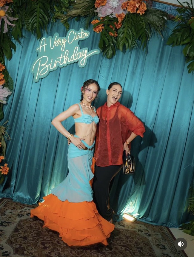 Luna Maya turut hadir. Ia memilih memadukan dress hitam panjang tanpa lengan dengan kemeja merah menerawang. Penampilannya tak kalah simpel dengan gaya rambut sleek bun. Foto: Instagram