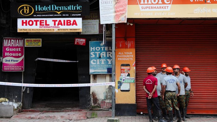 Emergency personnel stand near an entryway to a hotel where a fire broke out and killed several people, in Kolkata, India, August 19, 2026. REUTERS/Sahiba Chawdhary