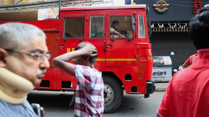 Emergency personnel stand near an entryway to a hotel where a fire broke out and killed several people, in Kolkata, India, August 19, 2026. REUTERS/Sahiba Chawdhary