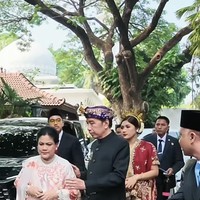 Iriana tampil anggun dengan kebaya bernuansa merah-putih. Ia mengenakan atasan putih berlengan panjang dengan detail motif floral dipadukan dengan kain bawahan berwarna cokelat. Foto: Instagram/@jokowi