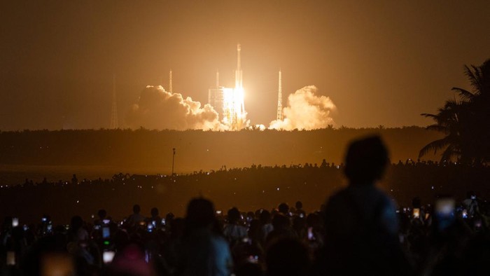 People gather at dusk at Qishui Bay Beach to watch the launch of a Long March 7A launch vehicle from the Wenchang Space Launch Site in Wenchang, Hainan province, China, August 10, 2026. On a sweltering August night, thousands on China's Hainan island thronged the beaches around the Wenchang Space Launch Site, phones raised, waiting for a show. Shortly after 8 p.m., the Long March 7A rocket blasted off. The crowd roared as its ascent lit up the night sky. Moments later, the uncrewed rocket turned into a ball of fire in midair, an unforeseen blast confirmed by Chinese state media a few hours afterwards. REUTERS/Maxim Shemetov            SEARCH 