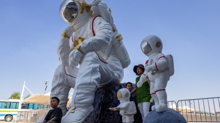 People gather at dusk at Qishui Bay Beach to watch the launch of a Long March 7A launch vehicle from the Wenchang Space Launch Site in Wenchang, Hainan province, China, August 10, 2026. On a sweltering August night, thousands on China's Hainan island thronged the beaches around the Wenchang Space Launch Site, phones raised, waiting for a show. Shortly after 8 p.m., the Long March 7A rocket blasted off. The crowd roared as its ascent lit up the night sky. Moments later, the uncrewed rocket turned into a ball of fire in midair, an unforeseen blast confirmed by Chinese state media a few hours afterwards. REUTERS/Maxim Shemetov            SEARCH 