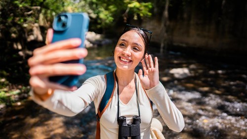 Young woman taking a selfie during exploration at forest