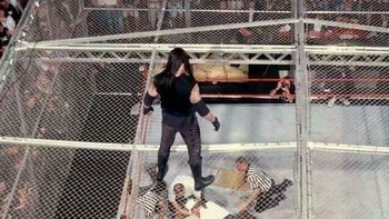 Pegulat The Undertaker menatap ke bawah ke arah tim medis yang sedang memeriksa Mankind setelah ia jatuh. Kejadiannya tidak direncanakan dalam naskah. Mankind menembus atap struktur Hell in a Cell hingga jatuh ke atas ring yang berada 4,5 meter di bawahnya. Peristiwa ini terjadi pada 28 Juni 1998. Mankind masih hidup sampai sekarang. Foto: OGWhiz via Bored Panda
