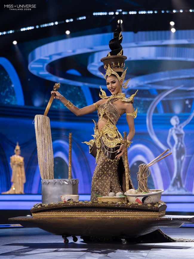 Oom-Nitinadda Krobram, kontestan Miss Universe Thailand 2026 yang mewakili Provinsi Nakhon Phanom, tampil dengan kostum bertajuk ‘Boat Noodle Set: Thai Way, Waterway Style.’ Sesuai namanya, kostum tersebut terinspirasi dari boat noodles, hidangan khas Thailand yang erat kaitannya dengan kehidupan masyarakat di sepanjang sungai. Foto: Dok. Facebook Miss Universe Thailand